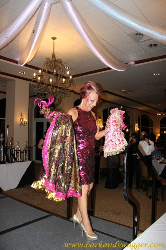 Designer dog fashions' big night at the Fabulous Cotillion. Here, Amy Cox holds Penelope and Paco Dos high as she struts the runway.